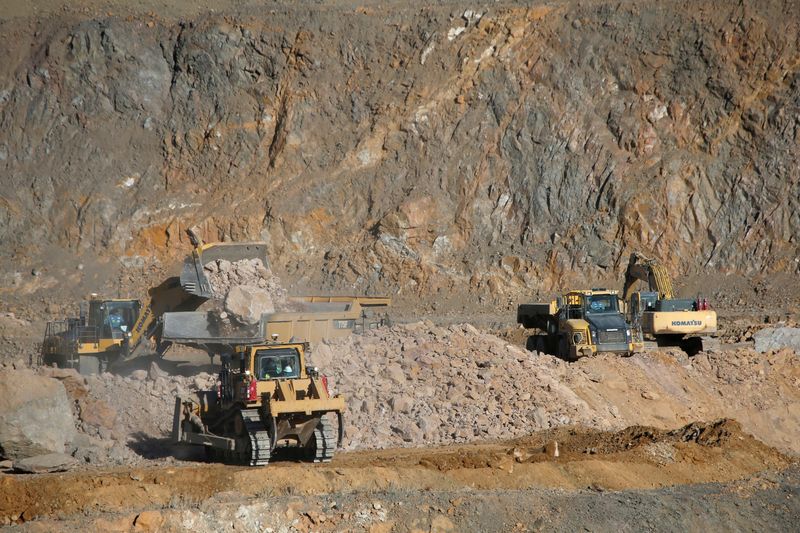 FILE PHOTO: Wheel loaders fill trucks with ore at the