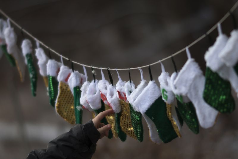 FILE PHOTO: A boy touches stockings, representing those killed in