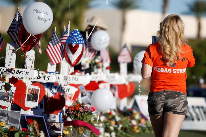 FILE PHOTO: A woman looks at white crosses set up