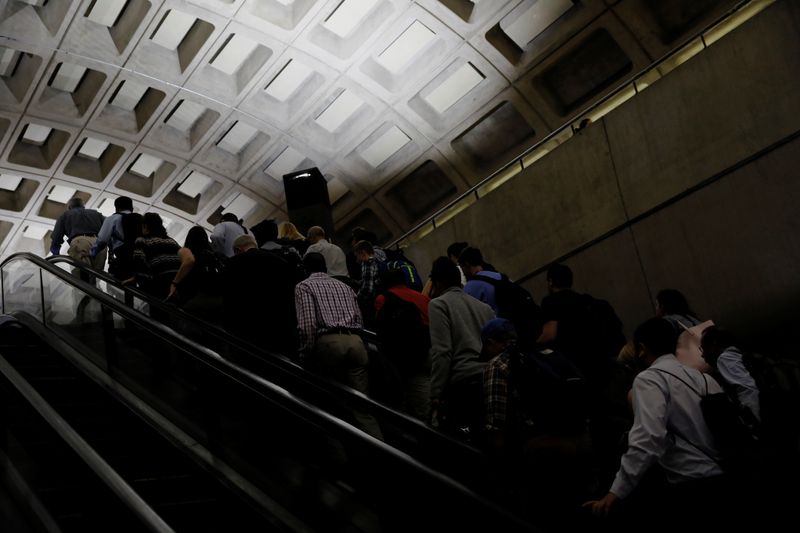 Commuters ride an escalator during the morning rush at the