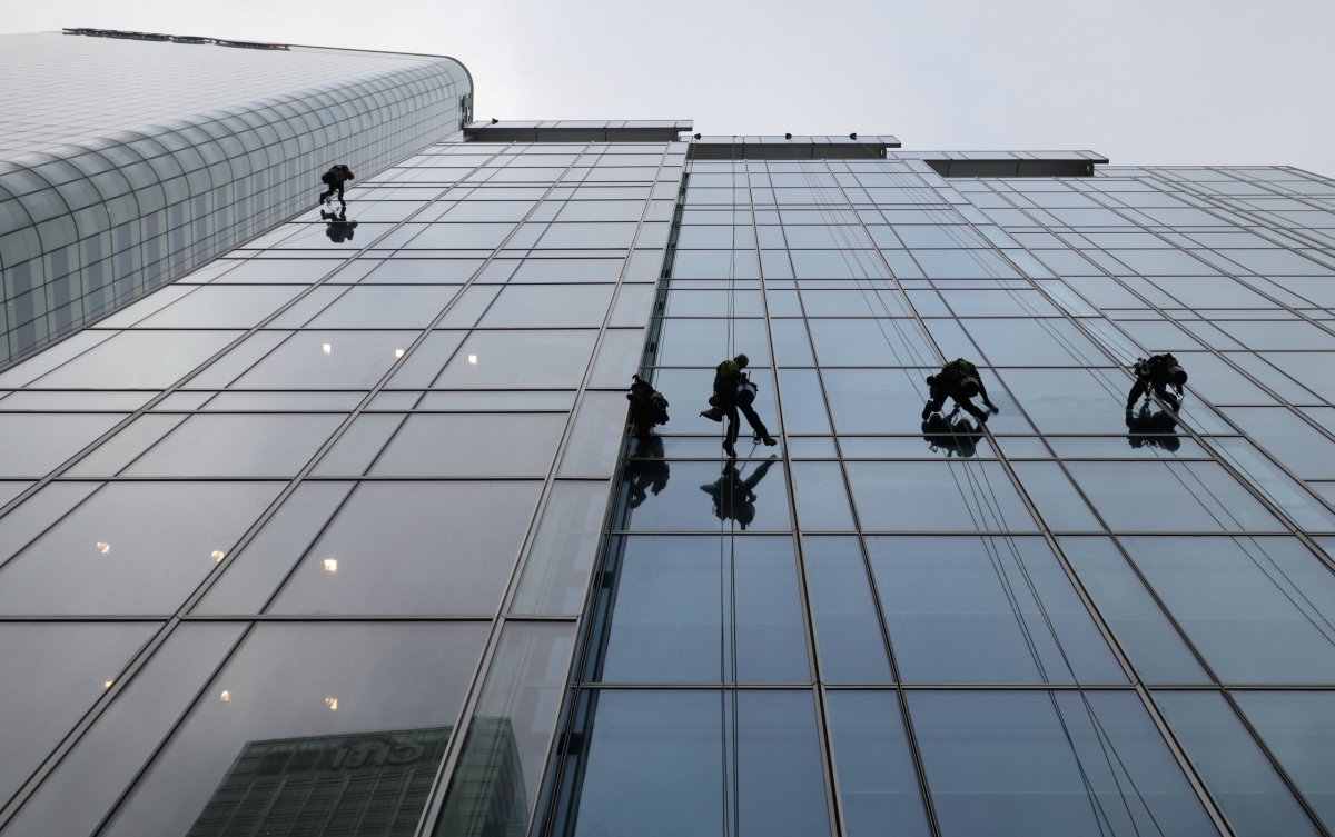 Workers clean the windows on the KPMG building in London’s
