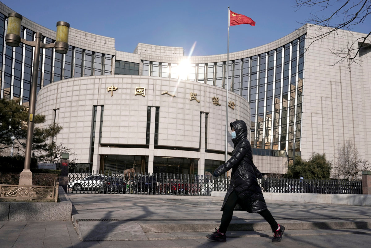 FILE PHOTO: Man wearing a mask walks past the headquarters