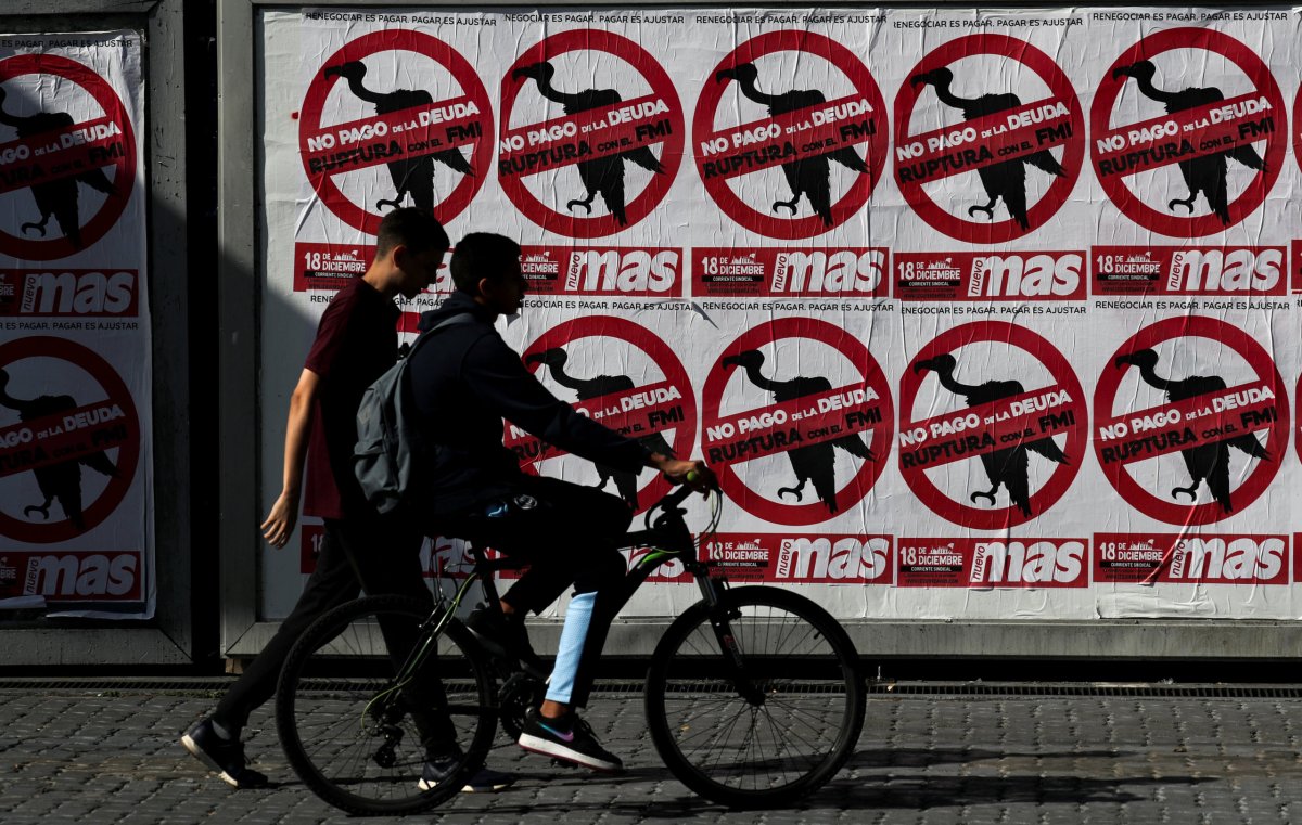 FILE PHOTO: Pedestrians walk past posters on the streets that