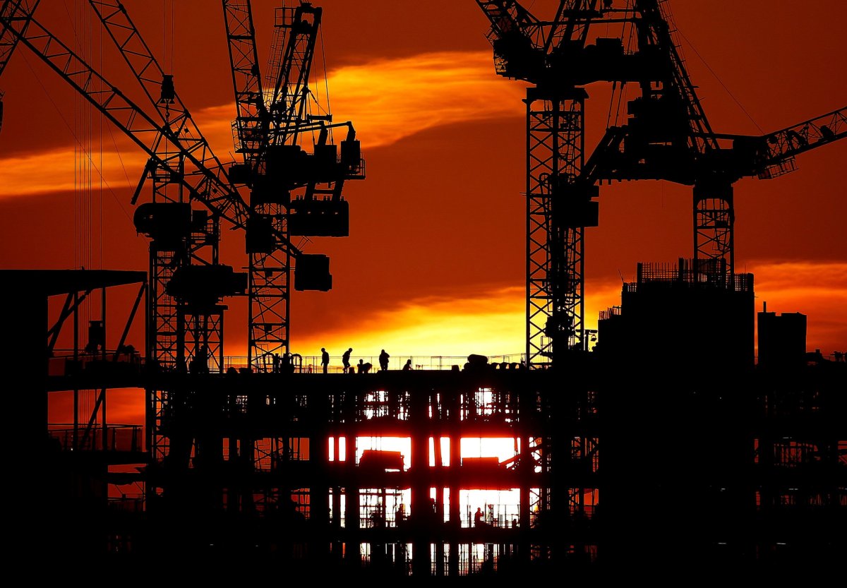 FILE PHOTO: Workers are seen as the sun sets behind