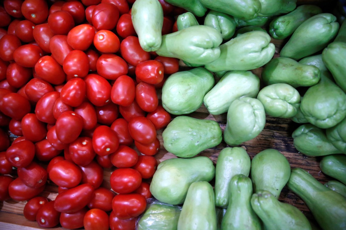 Tomatoes and chayotes are pictured at a groceries stall at