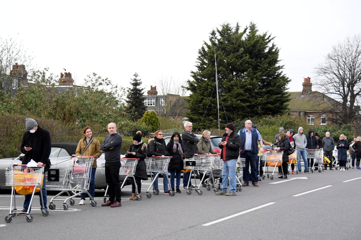 FILE PHOTO: Shoppers queue to enter a Sainsbury’s supermarket in