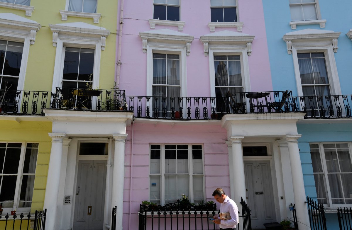FILE PHOTO:  A man walks past houses painted in