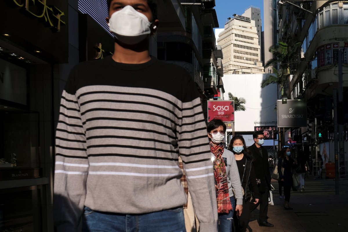 People wearing protective masks walk outside a shopping mall at