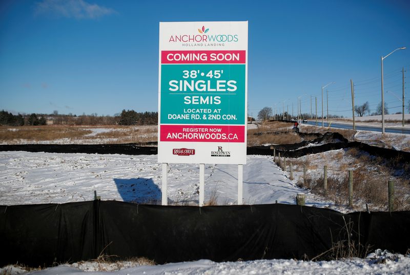 A sign advertising the sale of new homes stands in