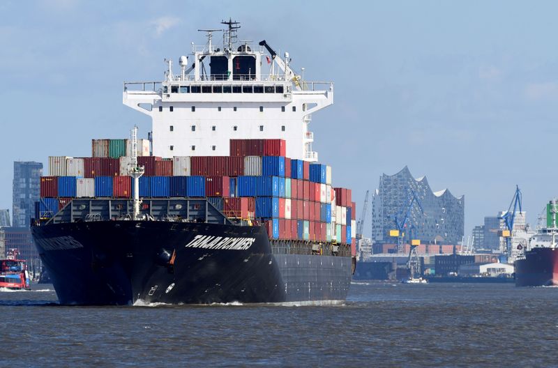 FILE PHOTO: A container ship leaves the port in front