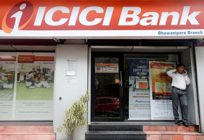 A man speaks on the phone outside an ICICI Bank
