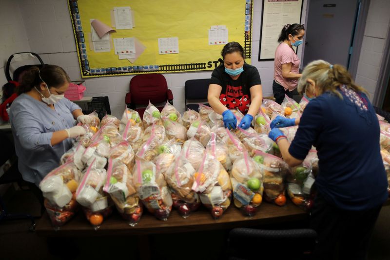Women prepare meals to hand out to children at the