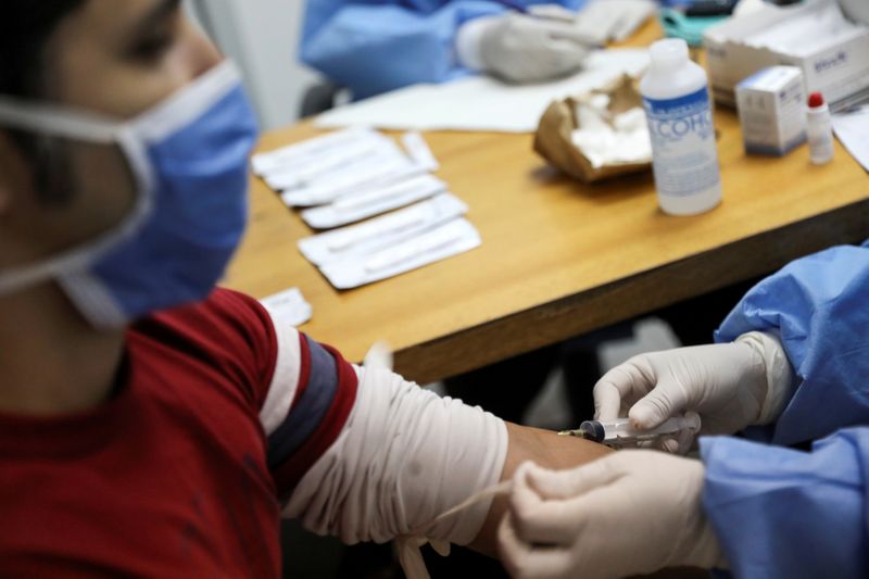 FILE PHOTO: Medical workers take blood samples from a man