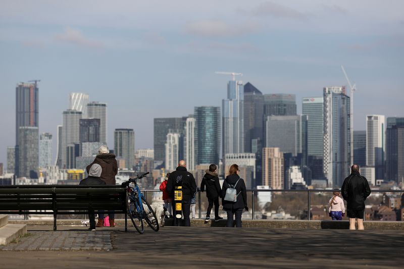 People look out onto the Canary Wharf district as they