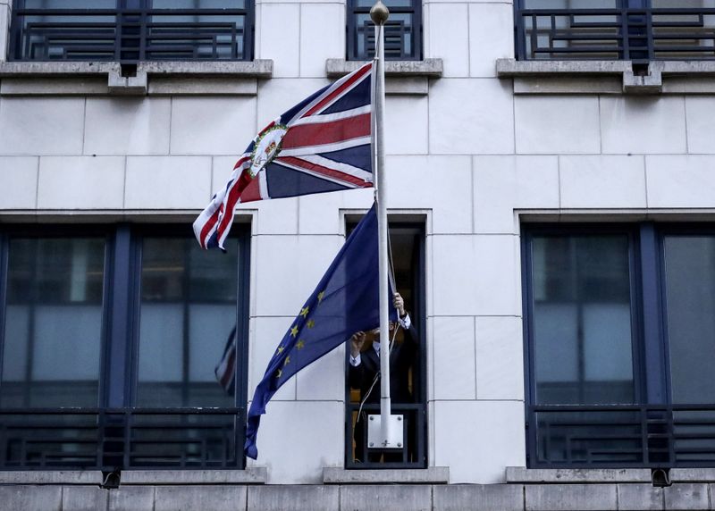 An official removes the EU flag from Britain’s Permanent Representation