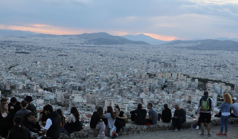 FILE PHOTO:  People sit overlooking Athens following the coronavirus