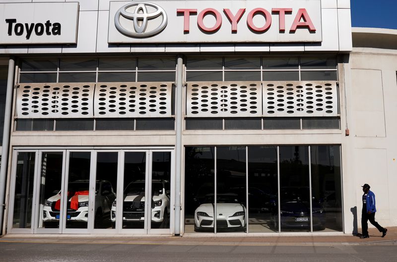 A man walks past a closed Toyota car dealership during