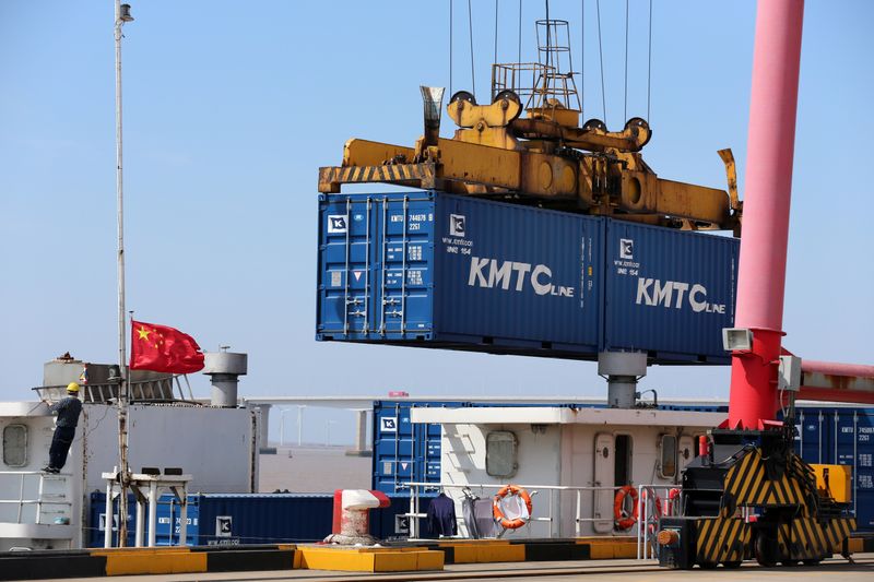 Crane lifts containers to be loaded onto a cargo vessel