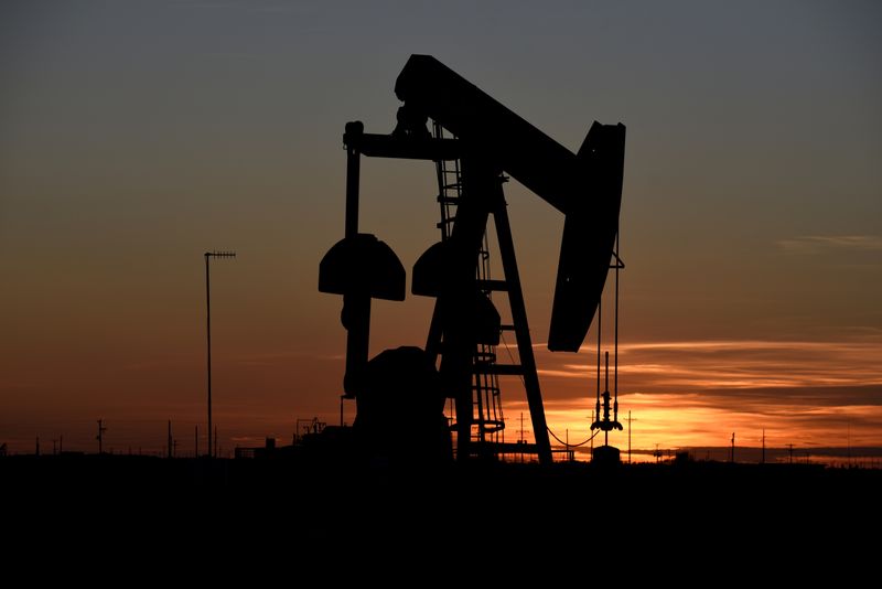 FILE PHOTO: A pump jack operates at sunset in an
