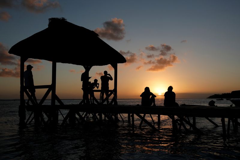 FILE PHOTO: People look at the sunset from the beach