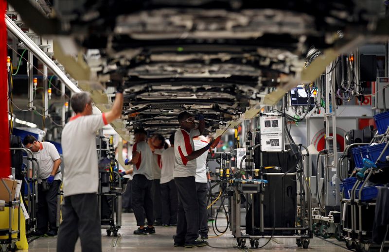 FILE PHOTO:  Workers assemble vehicles on the assembly line