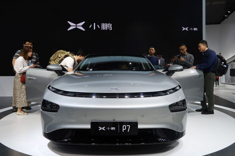 People look at XPeng’s P7 sedan model displayed at the