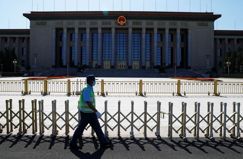 Security guard walks past the Great Hall of the People,