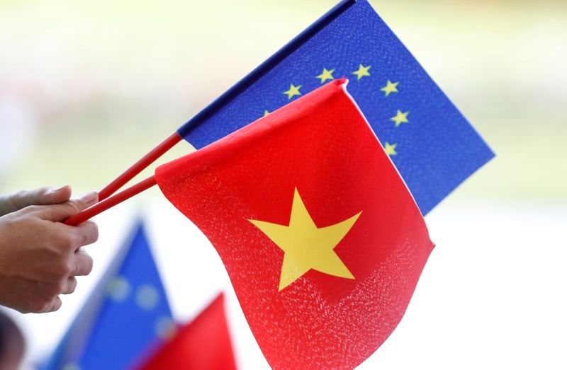 European Union and Vietnamese flags are seen at the signing