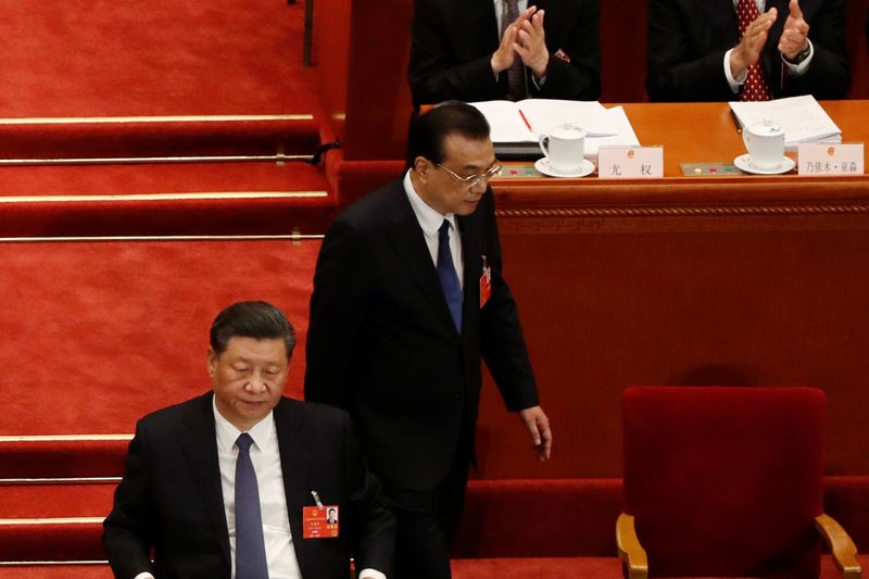Chinese Premier Li Keqiang returns to his seat next to