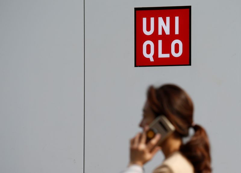 FILE PHOTO: A woman walks past a Uniqlo store at