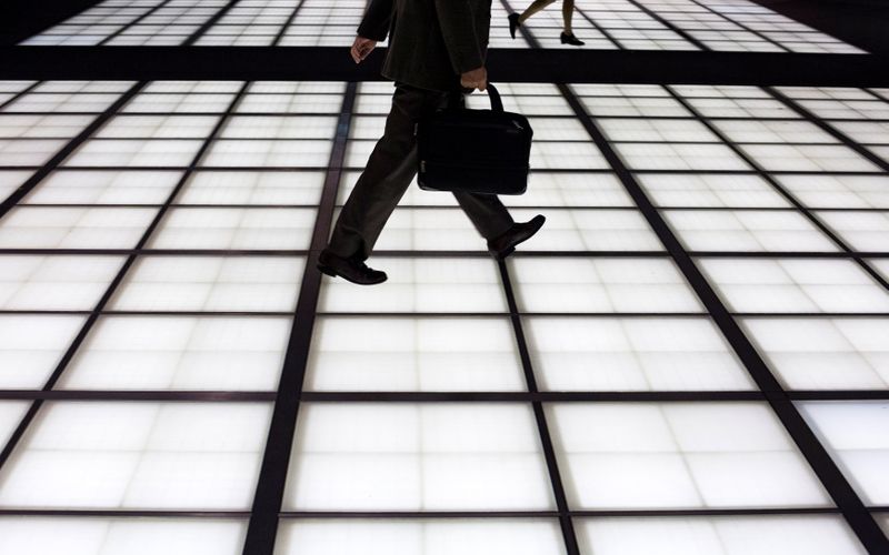 People cross an illuminated floor at a banking district in