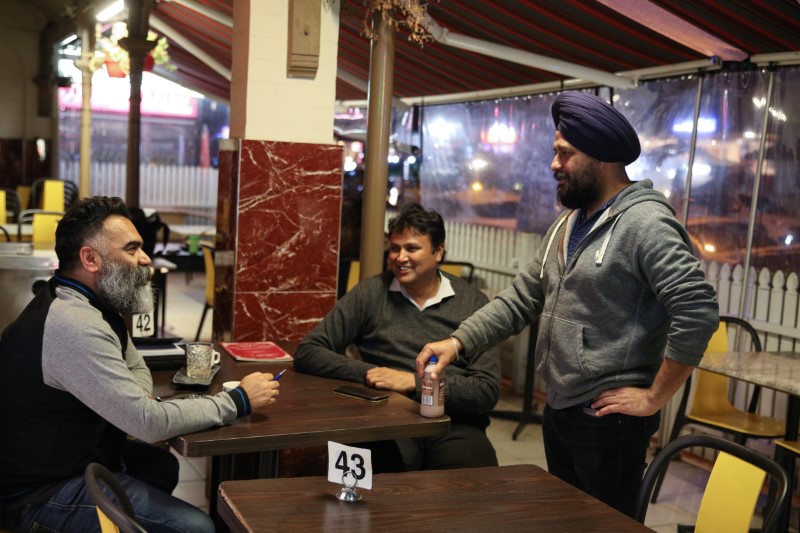 Small business owners visit an Indian restaurant, amidst the easing