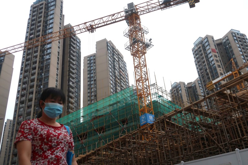 Woman wearing a face mask walks past a construction site