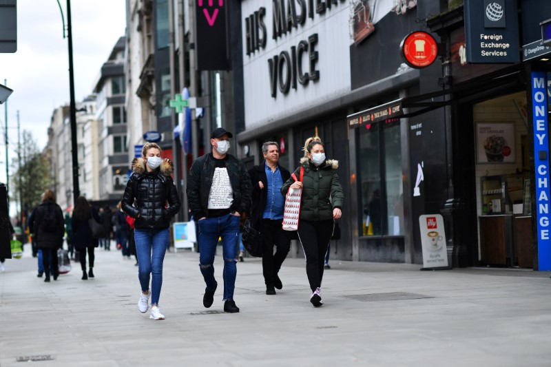 People wear masks as they walk down Oxford Street in