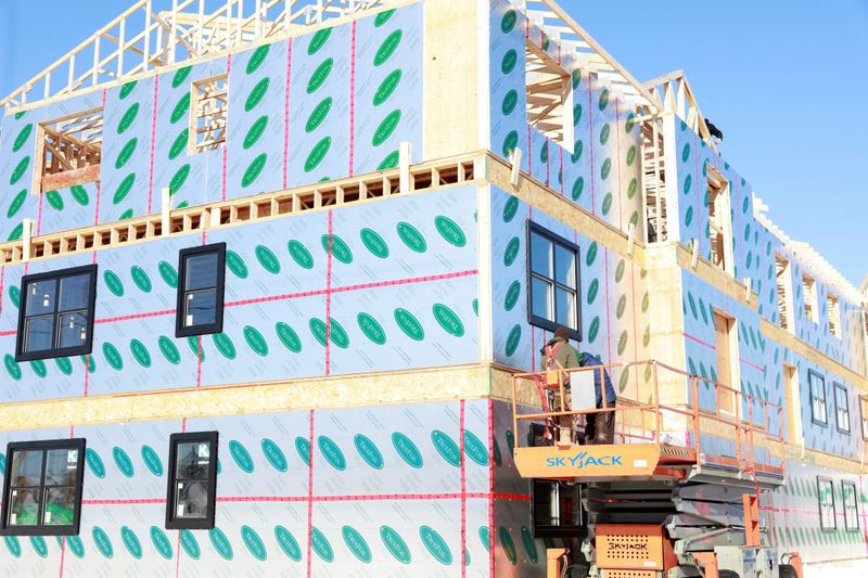 Workers guide equipment at a condominium development in Charlottetown, Prince