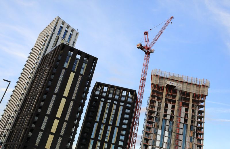 A crane is seen above some high rise building construction