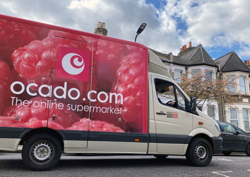 An Ocado delivery van is driven along a road in
