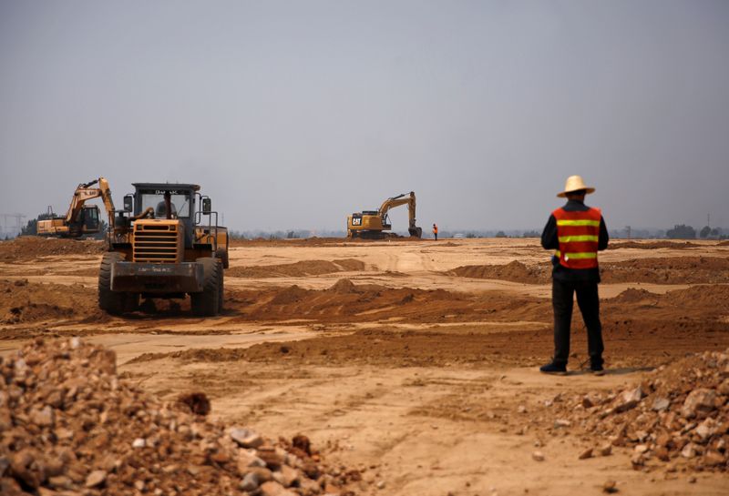 Workers and excavators are seen at a construction site of