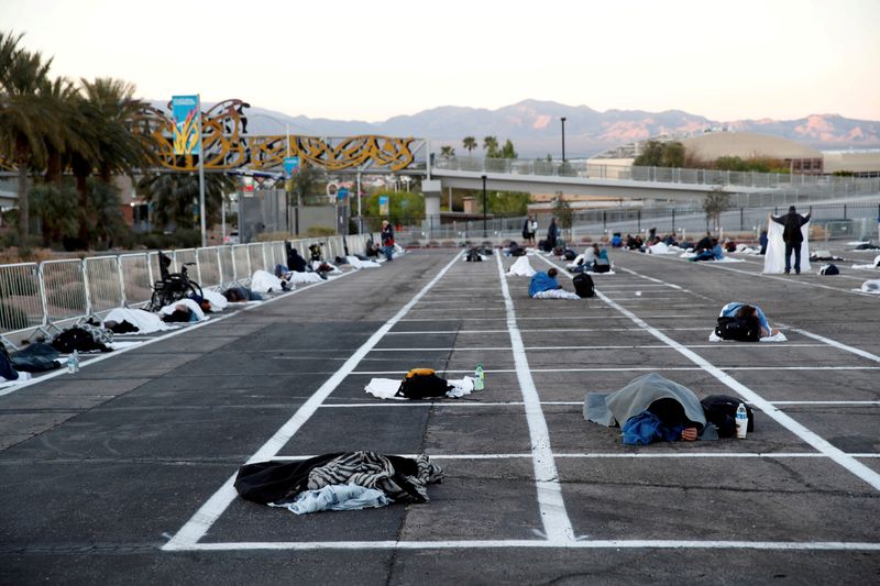 FILE PHOTO: Homeless people sleep in a parking lot with