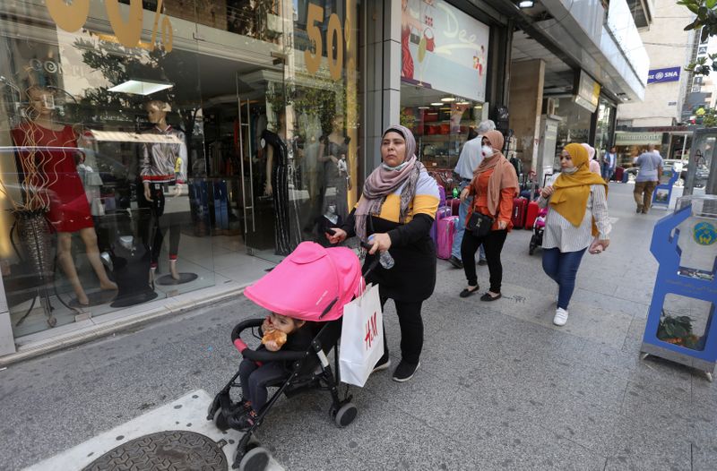 FILE PHOTO: Women walk past open shops in Hamra street