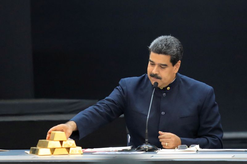 FILE PHOTO: Venezuela’s President Maduro touches a gold bar as
