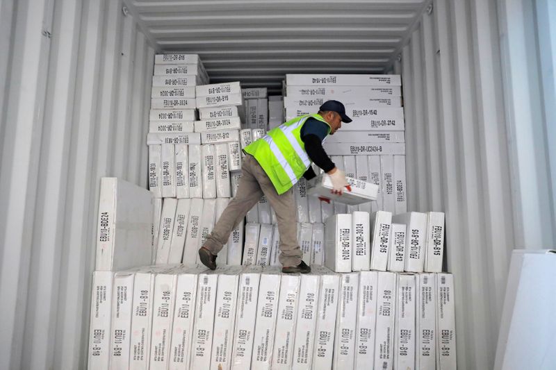 FILE PHOTO: A worker unloads a delivery from Indonesia CNC
