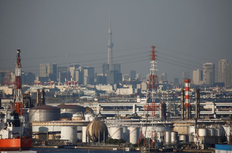 Chimneys of an industrial complex and Tokyo’s skyline are seen