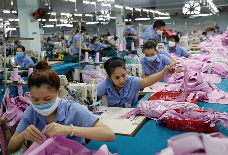 FILE PHOTO: Labourers work at a garment assembly line of