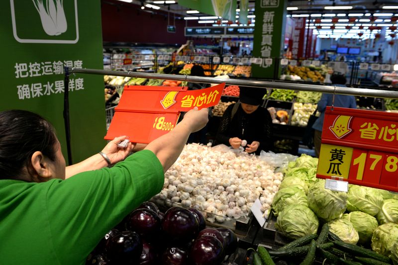 FILE PHOTO: Staff member inserts a price tag for vegetable