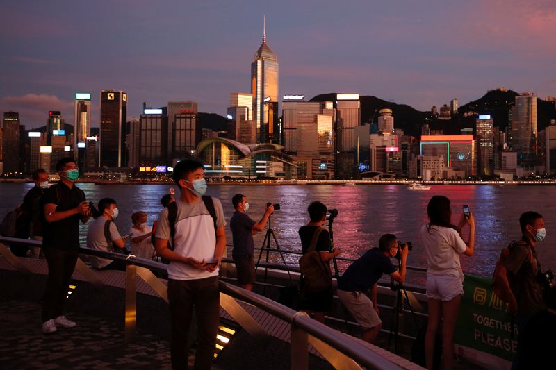 People enjoy the sunset view with a skyline of buildings