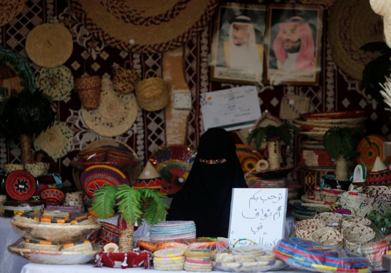 A Saudi woman sits in her shop at heritage village