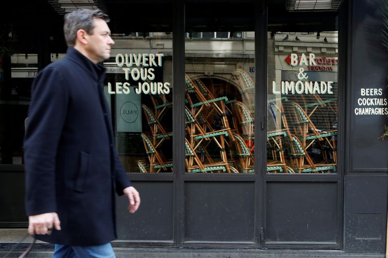 FILE PHOTO: A man walks past closed restaurant, as France