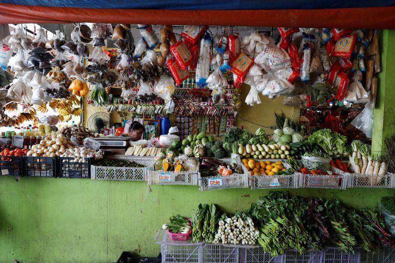 A woman waits for customers inside a food market in
