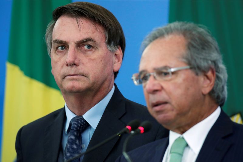 FILE PHOTO: Brazil’s President Jair Bolsonaro listens Brazil’s Economy Minister